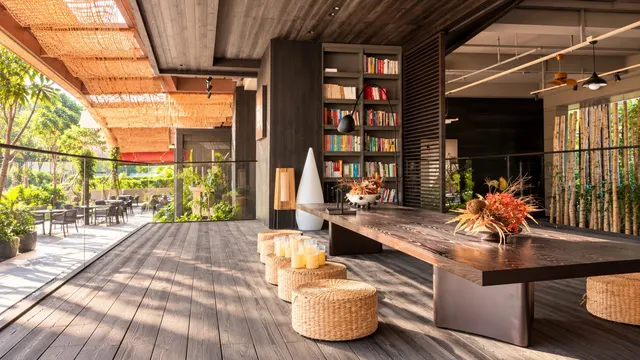 Open-air lounge with bookshelves and a long wooden table